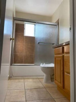 Renovated bathroom with tub and modern fixtures in a studio apartment near Belmont Park.