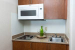 Cozy kitchenette with a microwave, sink, and modern design in a Baton Rouge apartment.
