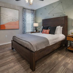 Cozy bedroom in an apartment with wood flooring, modern decor, and natural light at Solis at Winter Park, Florida.
