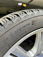Close-up of a Michelin X-Ice Snow tire showing tread pattern on a 2020 Tesla Model S wheel.