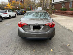 Rear view of a 2017 Toyota Corolla LE parked on the street with clean title and backup camera.