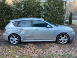 Side view of a 2007 Mazda 3 i Sport hatchback with visible wear and a cracked windshield.