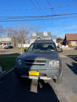 2003 Nissan Xterra with 89,000 miles for repair or parts, champagne color, in a residential area.