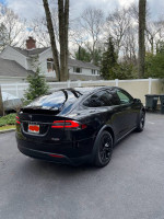 Fully loaded 2016 Tesla Model X P100D with motorized spoiler parked in a residential area.