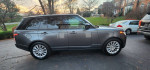 Side view of a 2018 Land Rover Range Rover HSE 4WD parked in a driveway, showcasing its sleek design and excellent condition.