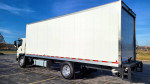 2021 Isuzu FTR box truck with liftgate, showcasing its white cab and box in a clear environment.