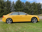 2010 Audi S4 in unique yellow color, parked on grass, showcasing its sleek design and alloy wheels.