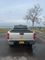 2012 Chevrolet Silverado 1500 rear view by the shore, showing its extended cab and minimal rust.