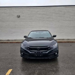 Front view of a black Honda Civic Sport with LED lights and alloy wheels parked in a lot.