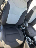 Interior seats of a 2014 Kia Soul with fabric upholstery and armrest, showcasing comfort and style.