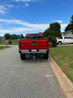 Rear view of a red 2015 Chevrolet Silverado 1500 parked on a residential street