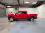Side view of a red Chevrolet Silverado 1500HD Classic pickup truck in a garage setting.