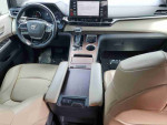Interior view of 2021 Toyota Highlander Hybrid Platinum with beige leather seats and dashboard display.