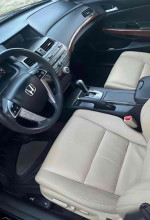 Interior view of a 2012 Honda Accord EX-L with beige leather seats and modern dashboard features.