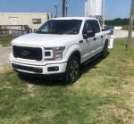 1998 Ford E-350 XL Club Wagon in white parked on grassy area, showcasing its excellent condition and low mileage.