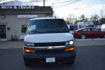 2016 Chevrolet Express Cargo Van in front of a truck dealership with commercial signage