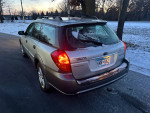 2007 Subaru Outback parked on a snowy road, showcasing its sleek design and winter tires.