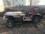 Restoration project of a 1959 Jaguar XK150 drophead coupe, showing surface rust and essential parts.