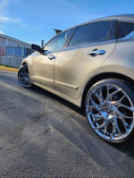 2015 Nissan Altima SL 2.5 with chrome wheels parked on the street, showcasing its sleek design.