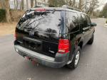 2005 Ford Explorer with 107,000 miles, black exterior, parked on a residential street.