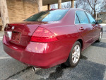 2006 Honda Accord EXL in red, showcasing the rear view with alloy wheels and clean design.