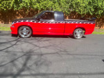 1995 Chevrolet S-10 Xtreme in red with custom flames and chrome wheels parked on the street.