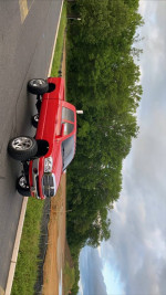 2006 Dodge Ram 2500 Mega Cab diesel truck in red parked on road with lush green trees