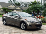 2012 Hyundai Elantra Sedan in excellent condition, grey-brown metallic exterior, parked in a scenic location.