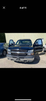 Front view of a clean 2003 Chevrolet Avalanche truck with open doors for sale, showcasing its interior.