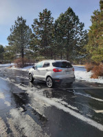 2020 Ford EcoSport Titanium FWD parked on snow-covered road, showcasing its sleek design and features.