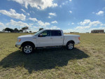 2013 Ford F150 Lariat 4X4 in white on open field, showcasing excellent condition and new tires