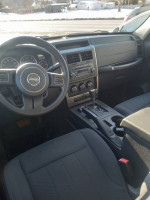 Interior view of a 2012 Jeep Liberty Sport with modern dashboard and seating in excellent condition.