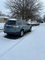 2009 GMC Acadia SUV parked on snowy street, featuring clean title and new tires for sale.