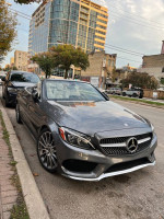 2017 Mercedes-Benz C300 Cabriolet in Selenite Grey parked on urban street with modern buildings