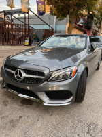 2017 Mercedes-Benz C300 Cabriolet in Selenite Grey Metallic parked on the street, showcasing its elegant design.
