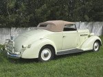 Classic 1936 Packard 120B convertible coupe with a beige top parked on grass.