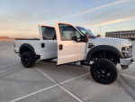 2009 Ford F250 Superduty Lariat Diesel truck with custom wheels and lift kit in parking lot
