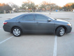 2009 Toyota Camry LE in gray, parked in a lot, viewed from the side, good condition with keyless entry.