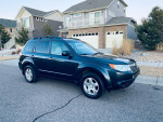 2010 Subaru Forester parked in a driveway, showcasing its clean exterior and all-wheel drive capability.