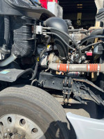 Close-up of 2016 Freightliner Cascadia engine and front wheel components, showcasing well-maintained parts.