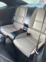 Interior view of the back seat in a 2010 Chevrolet Camaro, featuring beige and black upholstery.