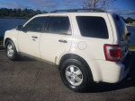 Side view of a 2009 Ford Escape XLT in white, parked near water with clean lines and shiny wheels.
