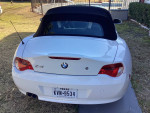 Rear view of a 2006 BMW Z4 convertible with a clean white exterior and black soft top.