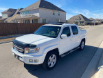 2010 Honda Ridgeline 4WD in white with leather interior and sunroof, parked in a residential area.