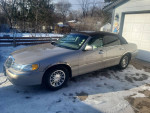 2001 Lincoln Town Car Signature RWD parked in a snowy driveway, showcasing pristine condition and elegant design.