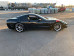 Black Chevrolet Corvette C5 with Z06 wheels, featured in parking lot, showcasing stylish modifications.