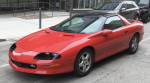 1997 Chevrolet Camaro RS in pristine condition with T-tops, showcasing sleek red exterior and polished rims.
