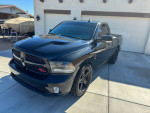 2015 Ram 1500 R/T in black with custom wheels, showcasing powerful supercharged HEMI and sleek design.