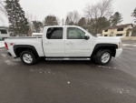 2011 Chevrolet Silverado 1500 LTZ 4WD in white, with crew cab and black accents, parked on snowy pavement.