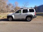 2009 Nissan Xterra 4x4 parked on a street, showcasing side profile and clean appearance.